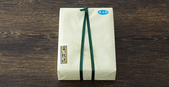 鮫小紋柄の包みとオリジナルの千社札。老舗料亭らしい贅沢な贈り物